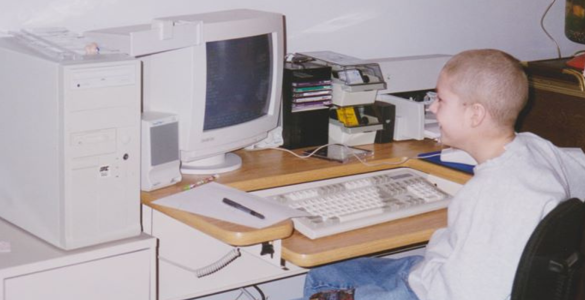 Steve as a child with buzz cut hear plays on 90s desktop computer setup