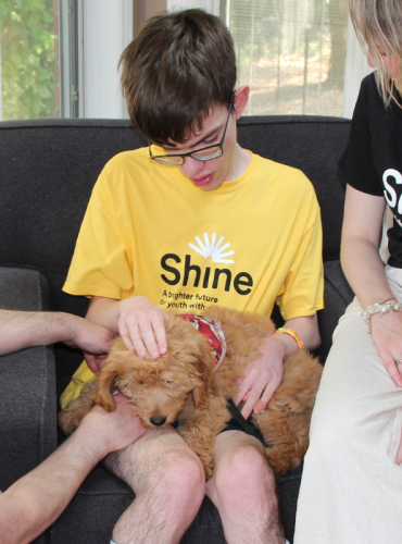 Shay's dad with Ciaran, his puppy Llew, and a Shine staff member