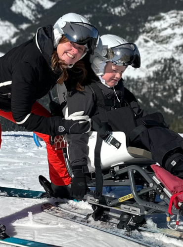 Young boy in sit-ski on mountainside