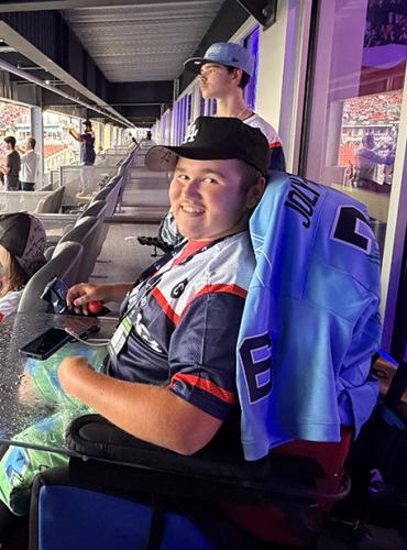 Teen boy in power wheelchair inside a Toronto Argonauts suite watching the football game