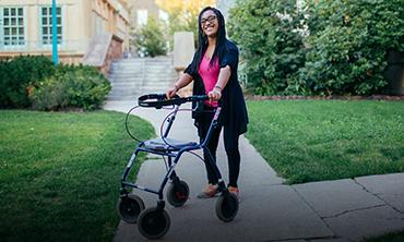 women standing behind her walker and smiling 