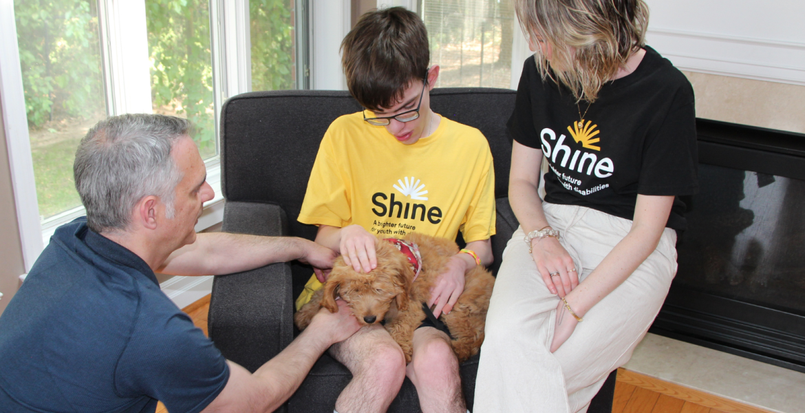 Shay's dad with Ciaran, his puppy Llew, and a Shine staff member