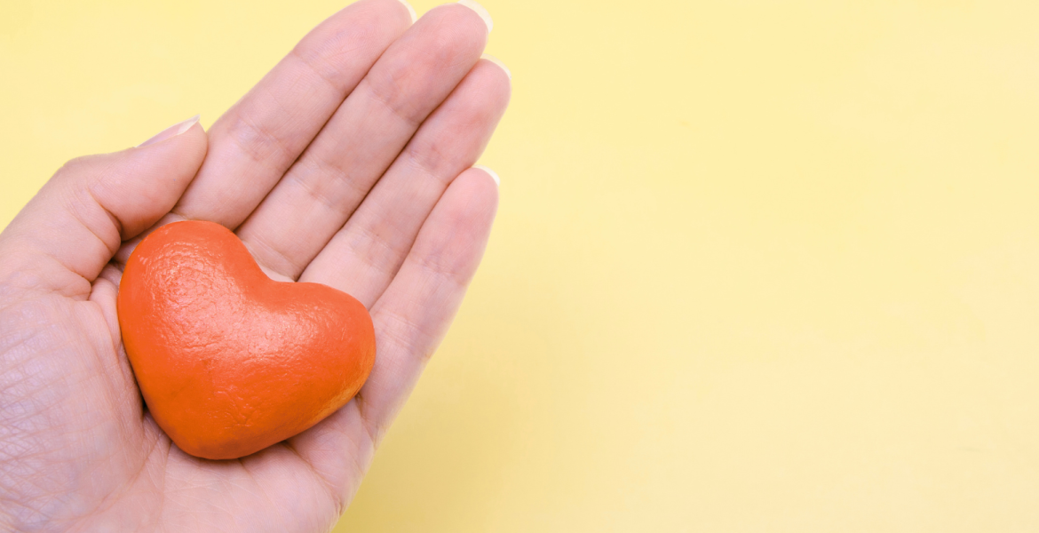 hand with heart on yellow background