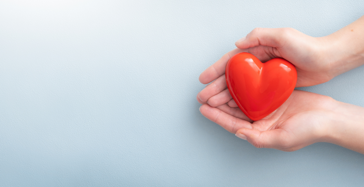 Cupped hands holding a heart shape in palms