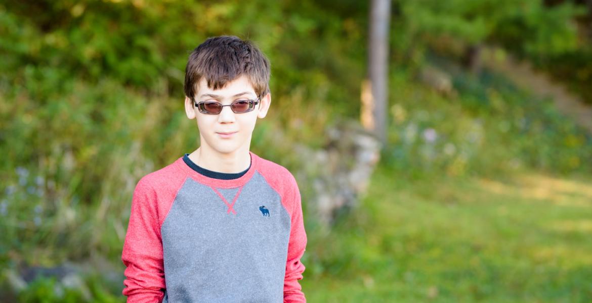 Randy wearing sunglasses standing in grassy outdoor area