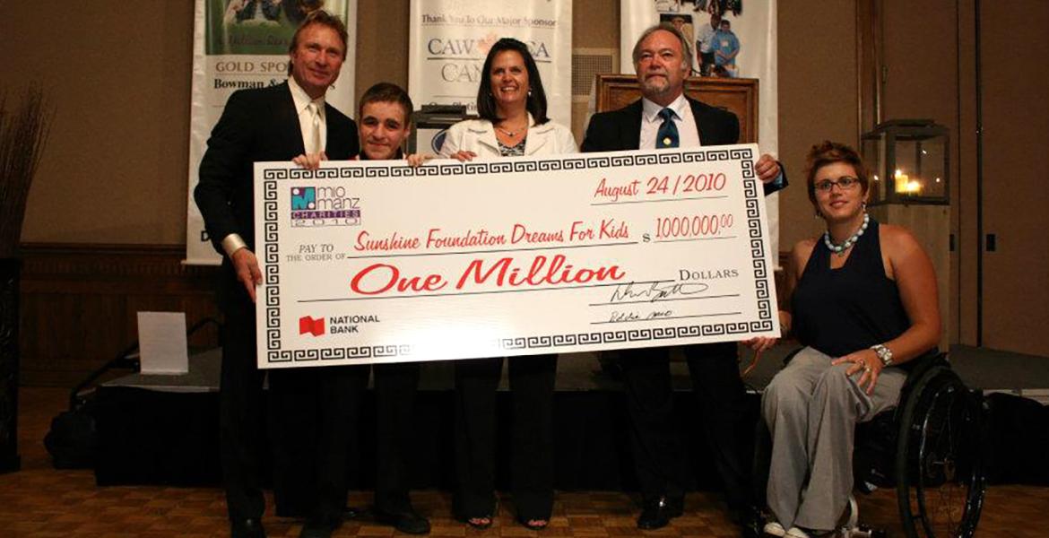 David poses with group behind oversized one million dollar cheque.