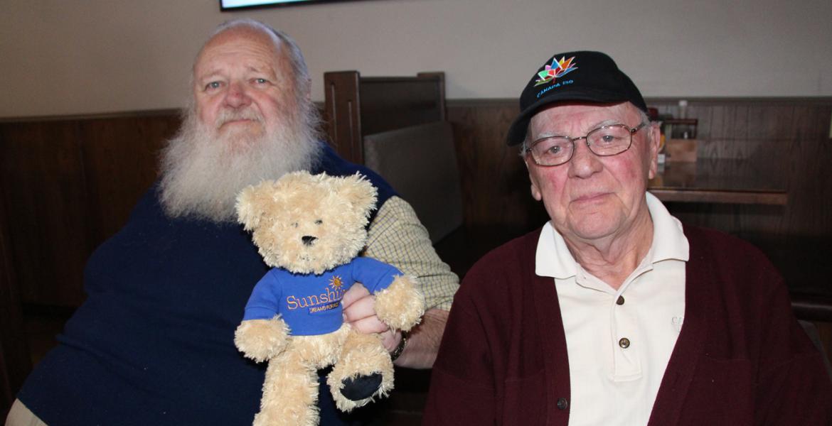 Jim and Larry holding Sunshine teddy bear