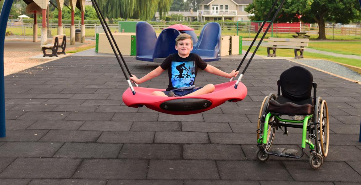 Lucas proudly sitting cross-legged in new saucer shaped swing